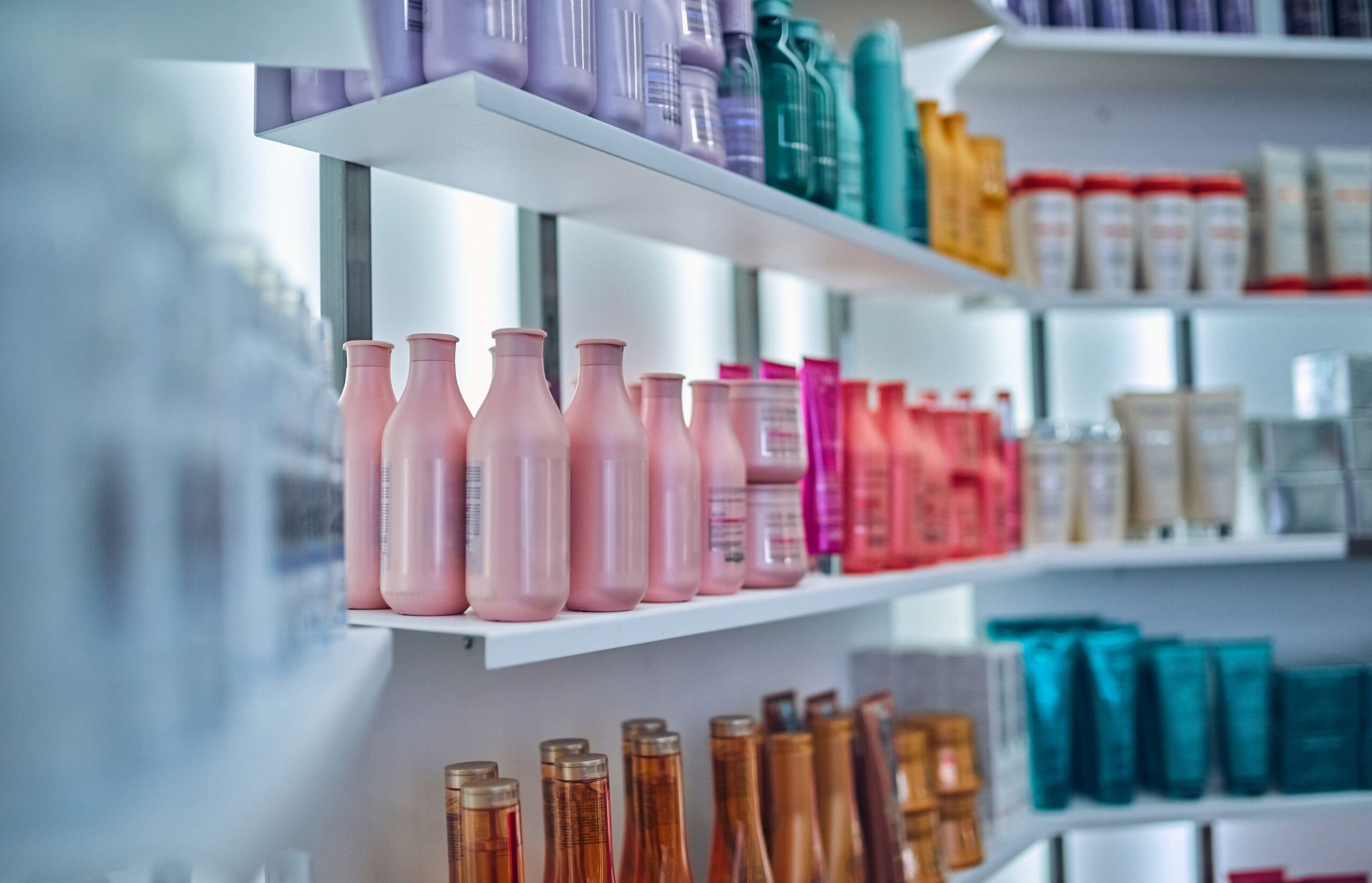 Beauty professional showcasing salon retail products to a client at the front desk; a visual representation of boosting product sales as a North Star strategy in the beauty industry.