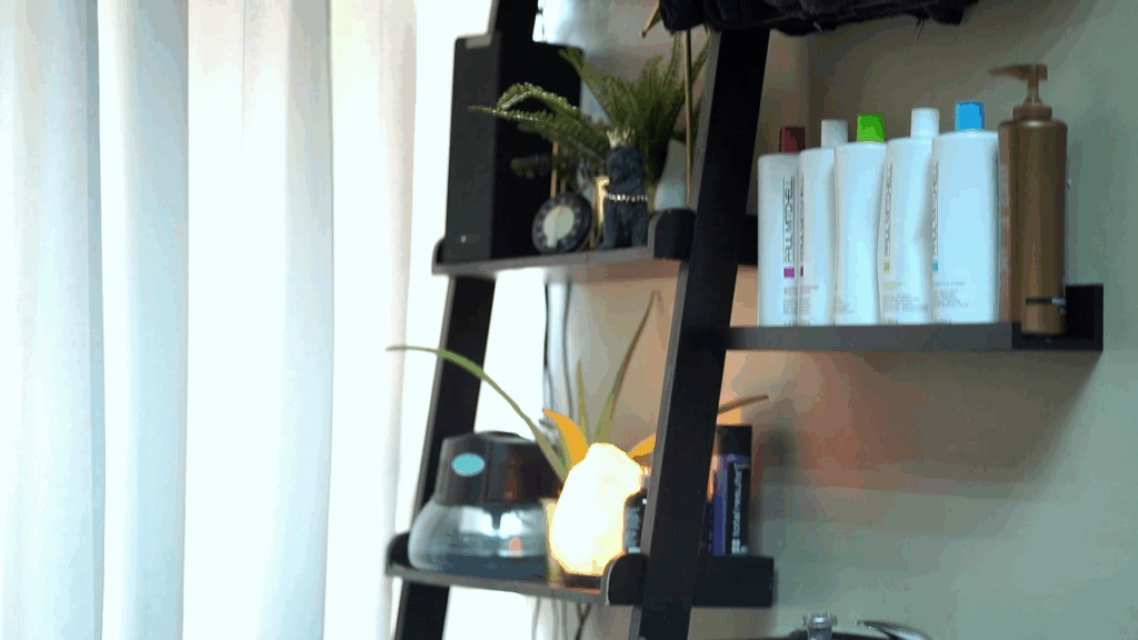 Beauty professional showcasing salon retail products to a client at the front desk; a visual representation of boosting product sales as a North Star strategy in the beauty industry.