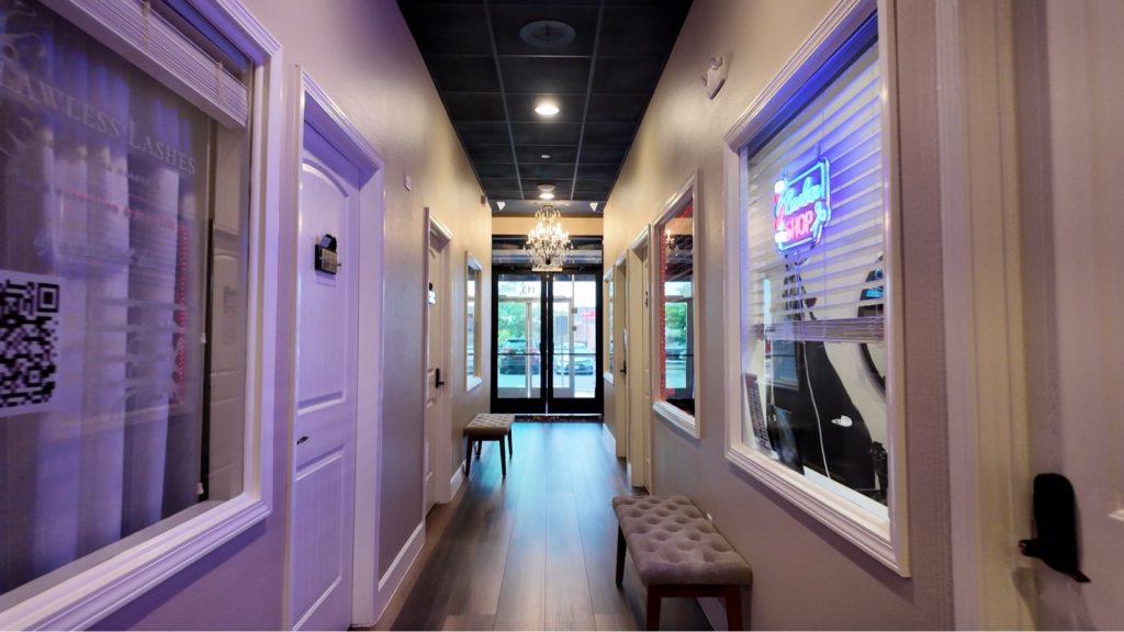 Softly lit hallway of private salon suites at Mallorca Salon Studios in San Antonio
