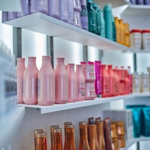 Beauty professional showcasing salon retail products to a client at the front desk; a visual representation of boosting product sales as a North Star strategy in the beauty industry.